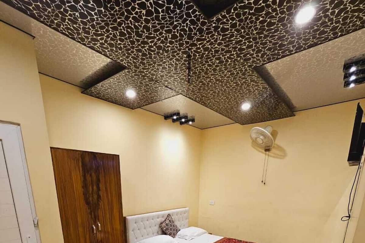 A bedroom with a bed, a wardrobe, a ceiling fan, and a door.