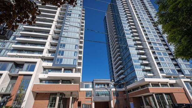 A modern high-rise building with multiple floors, large windows, and a mix of glass and brick facades. - Executive 2BD+Wifi+Parking+EV (Kitchener)