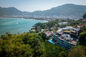 Uma cidade costeira com edifícios modernos, uma praia e vegetação exuberante.