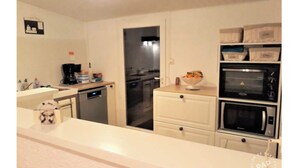 A compact kitchen with a dishwasher, a microwave, and a refrigerator. - Rental House St Hilaire De Riez 6/8 people 300 m from the beach, 2 stars (Saint-Hilaire-de-Riez)