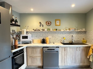 A modern kitchen with a built-in dishwasher, a microwave, and a sink.