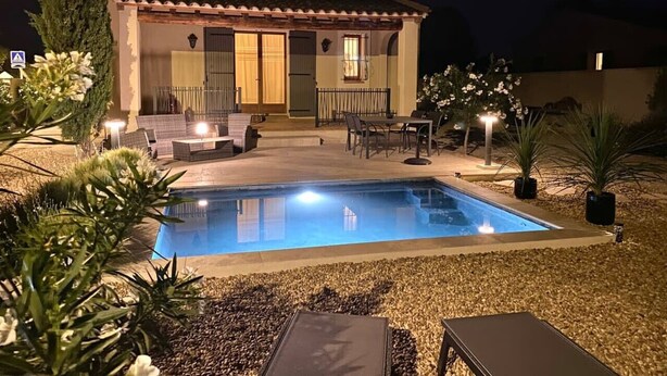 A house with a swimming pool, outdoor seating, and a well-lit patio area. - Les Lauriers Blancs, air-conditioned villa with swimming pool (L'Isle-sur-la-Sorgue)