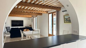 Eine moderne Küche mit dunkler Arbeitsplatte, weißen Schränken und Holzboden.