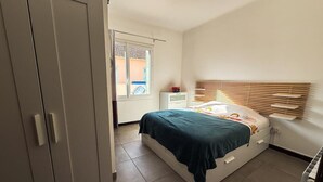 A bedroom with a bed, a wardrobe, a window, and a bedside table. - Villa Keromate, air-conditioned villa with natural pool. (Entraigues-sur-la-Sorgue)