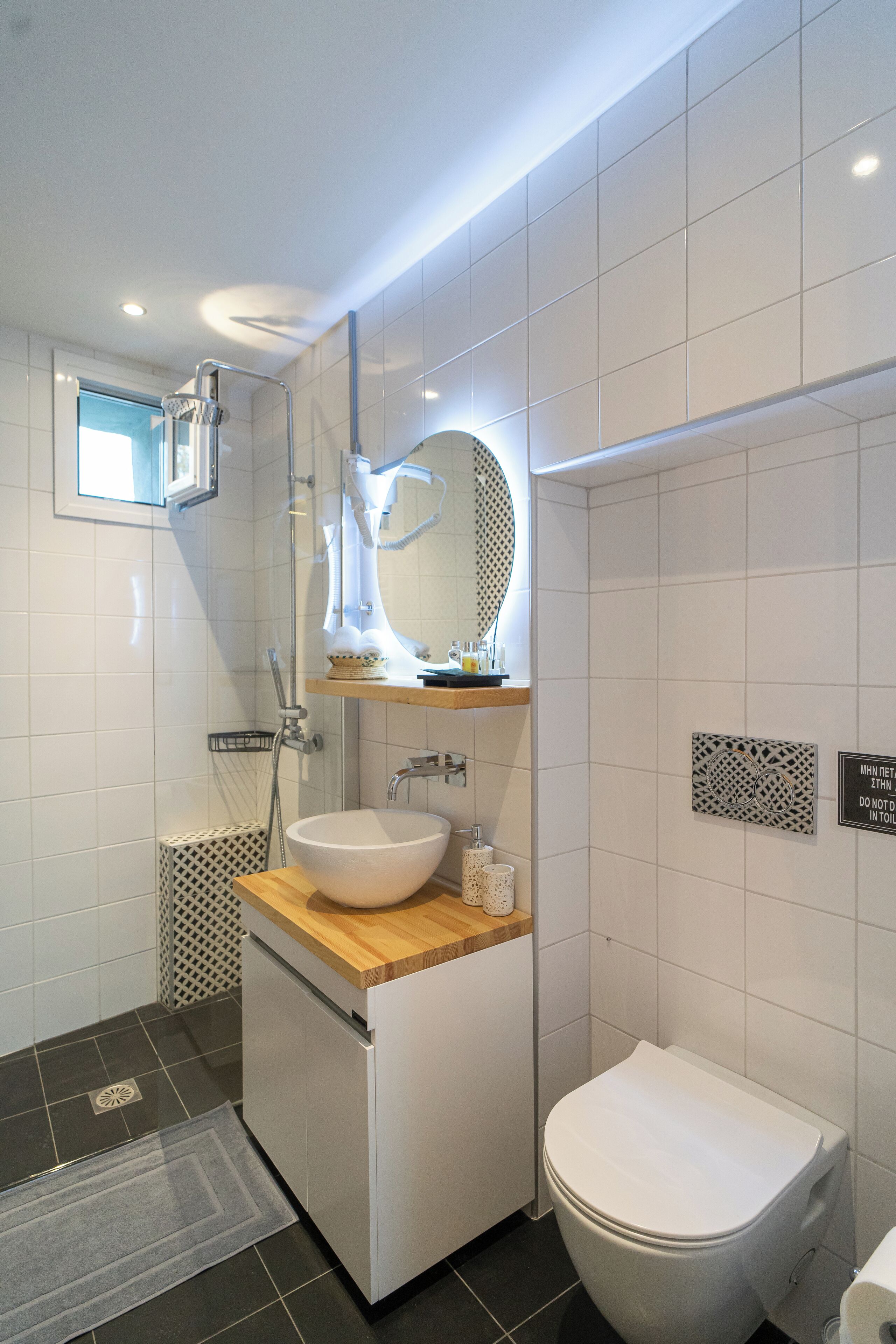 A modern bathroom with a white sink, a toilet, and a shower area.