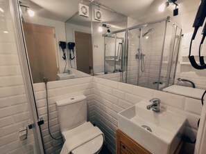 Regadera, secadora de cabello, toallas, papel de baño 