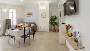 Una cocina moderna con comedor, un televisor de pantalla plana en la pared y una planta en maceta.