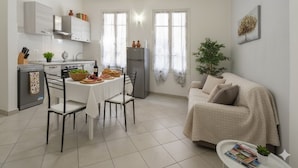 Un espacio habitable pequeño con cocina, comedor y sofá.