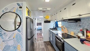 Une cuisine compacte équipée d’un réfrigérateur, d’une cuisinière, d’un évier et d’un four à micro-ondes.