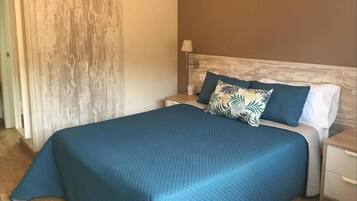 A bedroom with a bed, nightstands, and a lamp.
