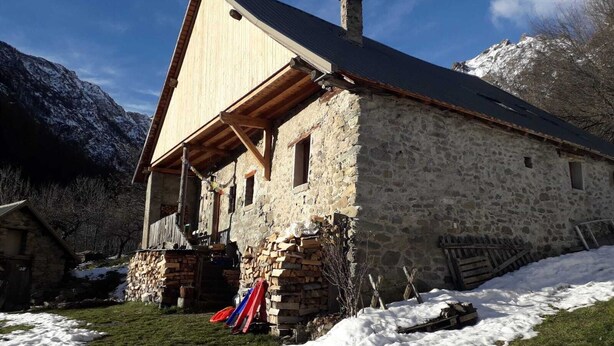 A stone building with a sloped roof, wooden beams, and a chimney. - Old renovated house in the heart of the Parc des Écrins for nature lovers (Champoléon)