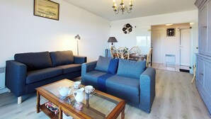 Una sala de estar con un sofá, una mesa de centro y un comedor con sillas y una mesa.
