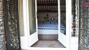 A room with a bed, a bookshelf, and a clock on the wall.