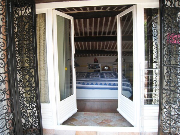 A room with a bed, a bookshelf, and a clock on the wall.