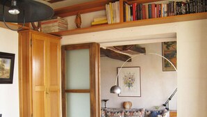 A cozy living room with a sofa, a wooden cabinet, a bookshelf, and a tiled floor.