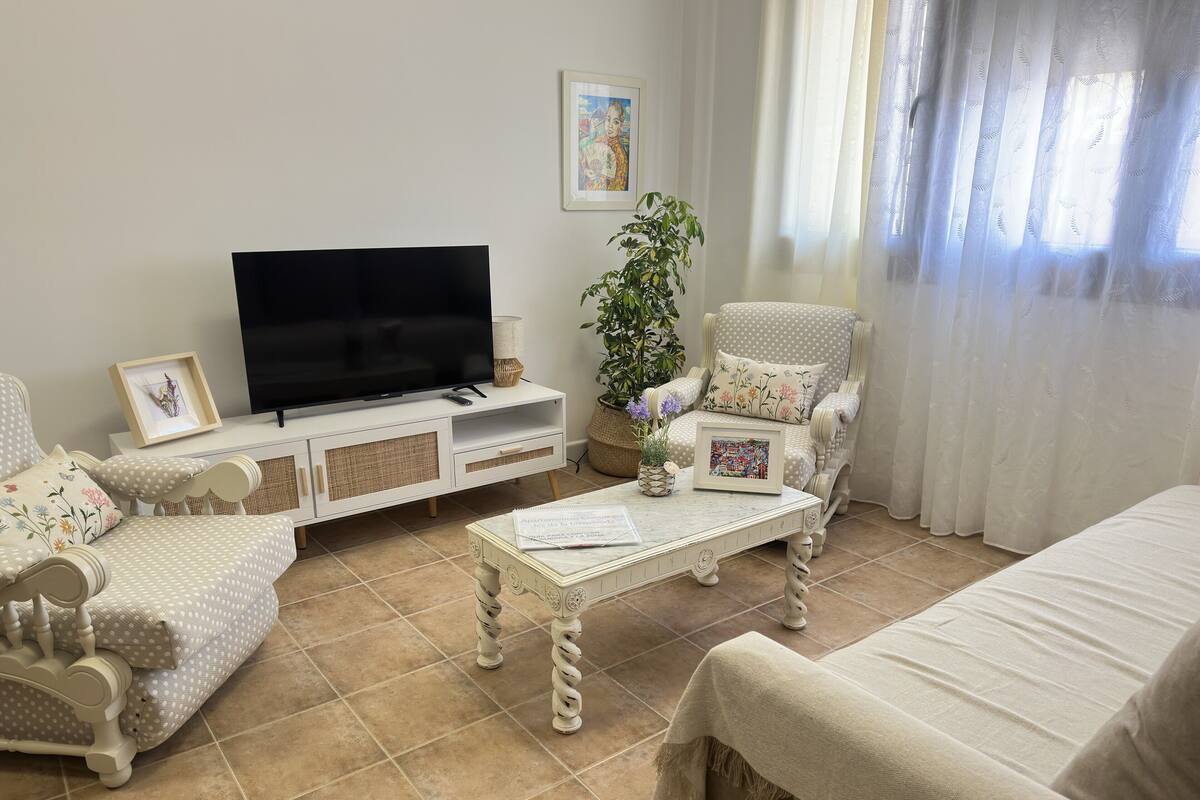 A living room with a television, a sofa, a chair, and a coffee table.