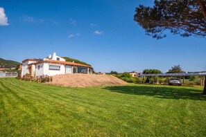 A residential property with a white house, a sloped roof, and a solar panel array. - La Sciumara With Beach Access (Arzachena)