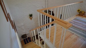 Eine Holztreppe mit weißen Geländern, die zu einer oberen Etage führt.