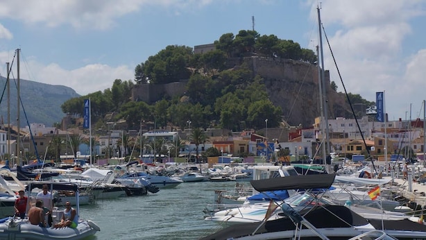 A marina with boats docked, a castle on a hill, and buildings in the background. - 1 Bed-sleeps 2-gardens-pool-10 Min To Beach (Denia)