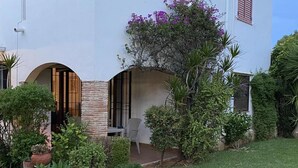 A white building with a garden, a patio, and a chair. - 1 Bed-sleeps 2-gardens-pool-10 Min To Beach (Denia)