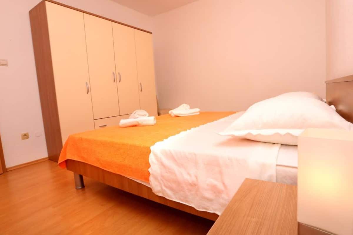 Une chambre à coucher avec un lit, une armoire en bois et une table de chevet en bois.