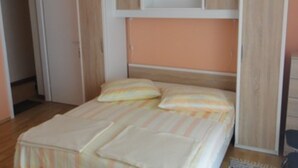 A bedroom with a bed, a wardrobe, and a door. - Seafront Apartments Pretner (Orebic)