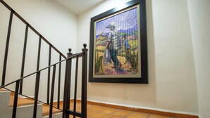 A staircase with a metal railing and a framed artwork on the wall.
