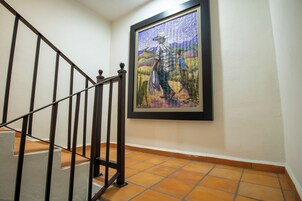 A staircase with a metal railing and a framed artwork on the wall.