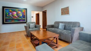 A living room with two grey sofas, a wooden coffee table, and a painting on the wall.
