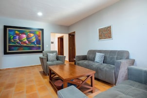 A living room with two grey sofas, a wooden coffee table, and a painting on the wall.