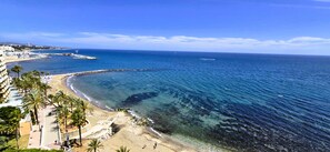 A coastal view with a beach, palm trees, and a clear blue sky. - Apto Isabel - Marbella Centro. Brand new to rentals for 2025.No car required! (Marbella)