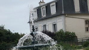 A fountain with water jets in a circular basin, surrounded by a brick border. - Granville, 50m from the sea, on the garden level, nice and cosy apartment-terrace for 2 persons (Granville)