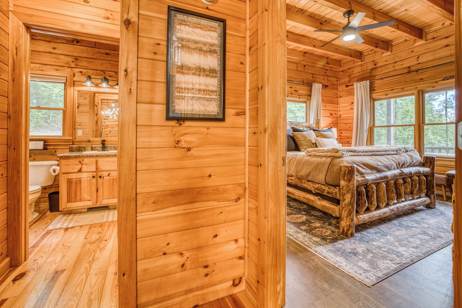 A wooden cabin interior with a bathroom, a bedroom with a bed, and a dining area.