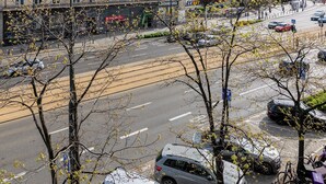Un hôtel Novotel au design moderne, situé dans un quartier urbain, avec un parking et entouré d’autres immeubles.