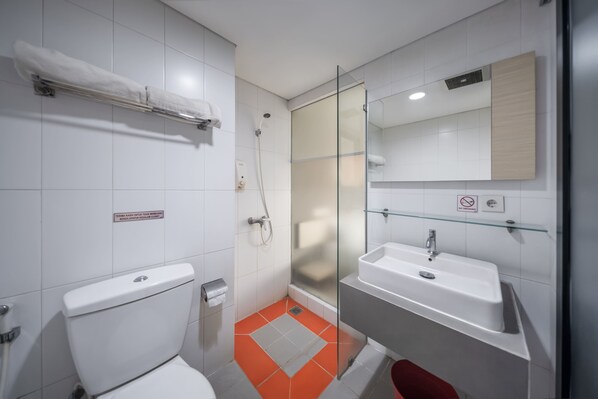 A modern bathroom with a toilet, shower, and sink. - Cove Wanadu (Curug)