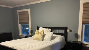 A bedroom with a bed, nightstands, a lamp, and a window with blinds. - Whole house - Park Ave 3 bedroom, enjoy all the neighborhood has to offer! (Rochester)