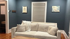 A living room with a beige sofa, a wooden coffee table, and a patterned rug. - Whole house - Park Ave 3 bedroom, enjoy all the neighborhood has to offer! (Rochester)