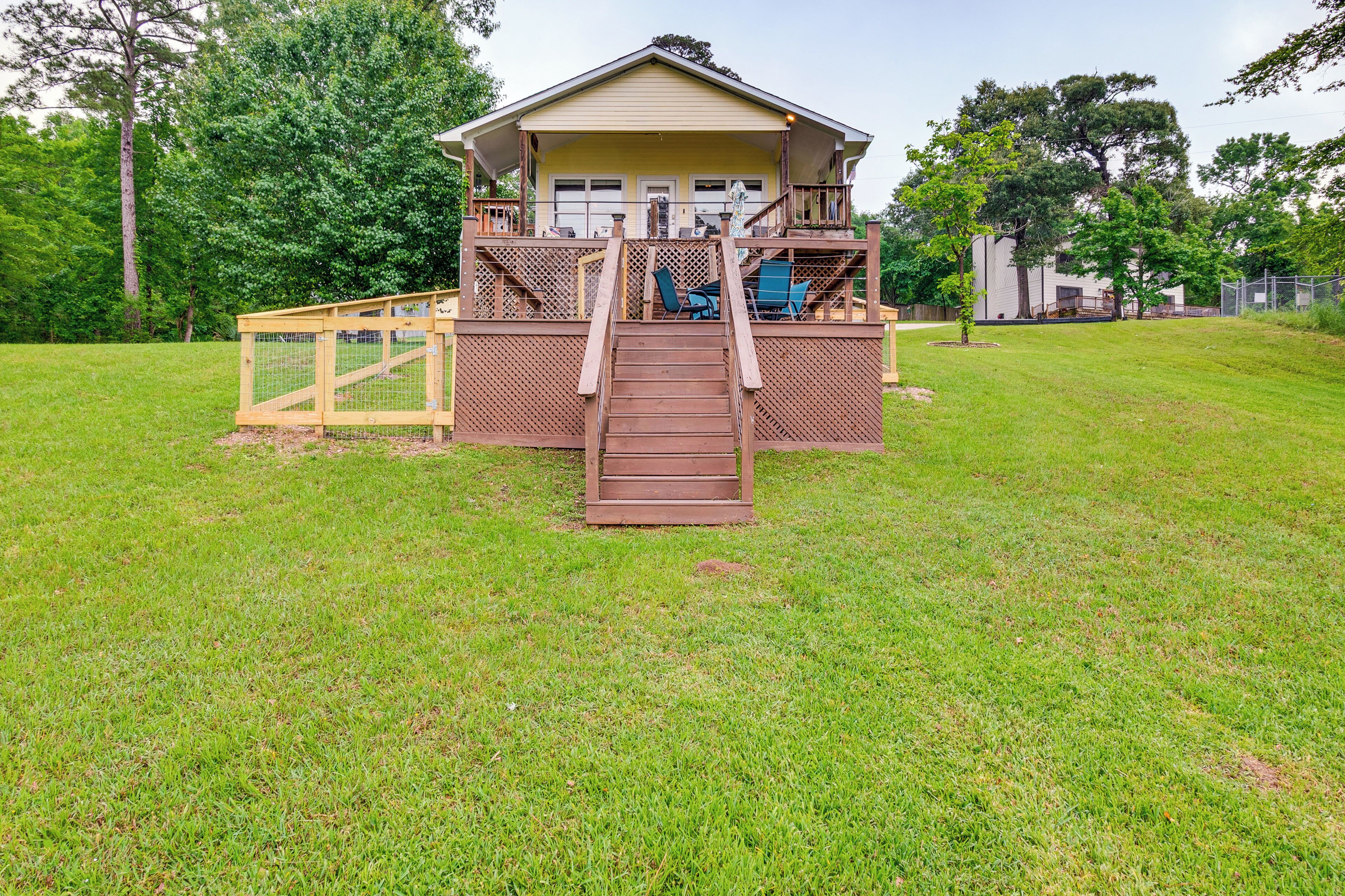 A two-story house with a deck and a staircase leading to the entrance.