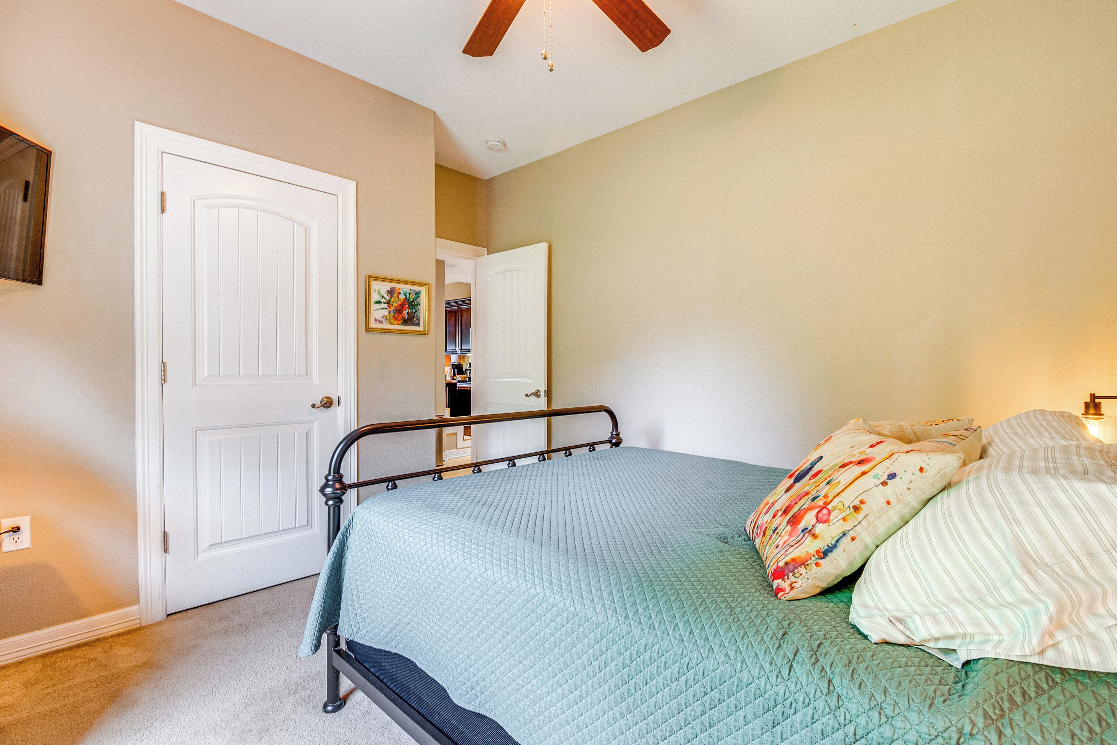 Ein Schlafzimmer mit Bett, Tür und Deckenventilator.
