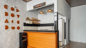 Una cocina moderna con una isla de madera, encimeras negras y un refrigerador negro.
