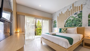 Una habitación de hotel moderna con una cama grande, un escritorio de madera, un mural de mármol y vistas a zonas verdes.