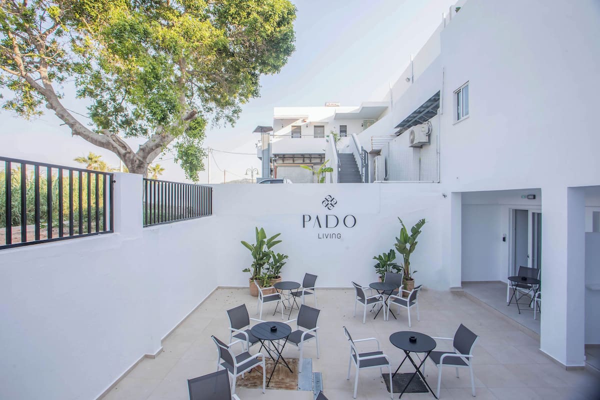 A Pado Living courtyard with outdoor seating and a large tree.