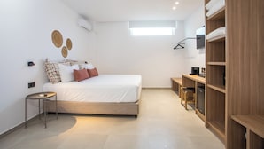 Une chambre moderne comprenant un lit, des tables de chevet, une armoire et un petit bureau.