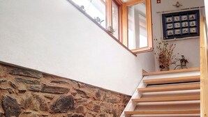 Un camino in pietra con una scala in legno che conduce a un secondo piano.