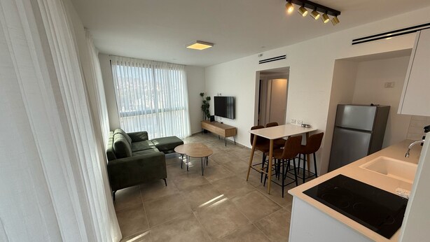 A modern apartment with a living area, dining space, and kitchen.