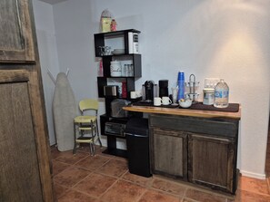 Compact kitchen with microwave, toaster oven, and sink.