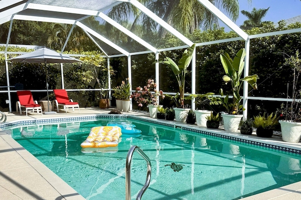 The pool deck has two lounge chairs, a sun umbrella and weber gas grill.