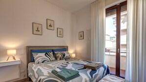 Une chambre à coucher avec un lit, des tables de chevet et une fenêtre avec des rideaux.