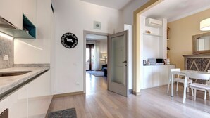 Une cuisine moderne dotée d’un plan de travail en marbre, d’une étagère intégrée et d’un four à micro-ondes.
