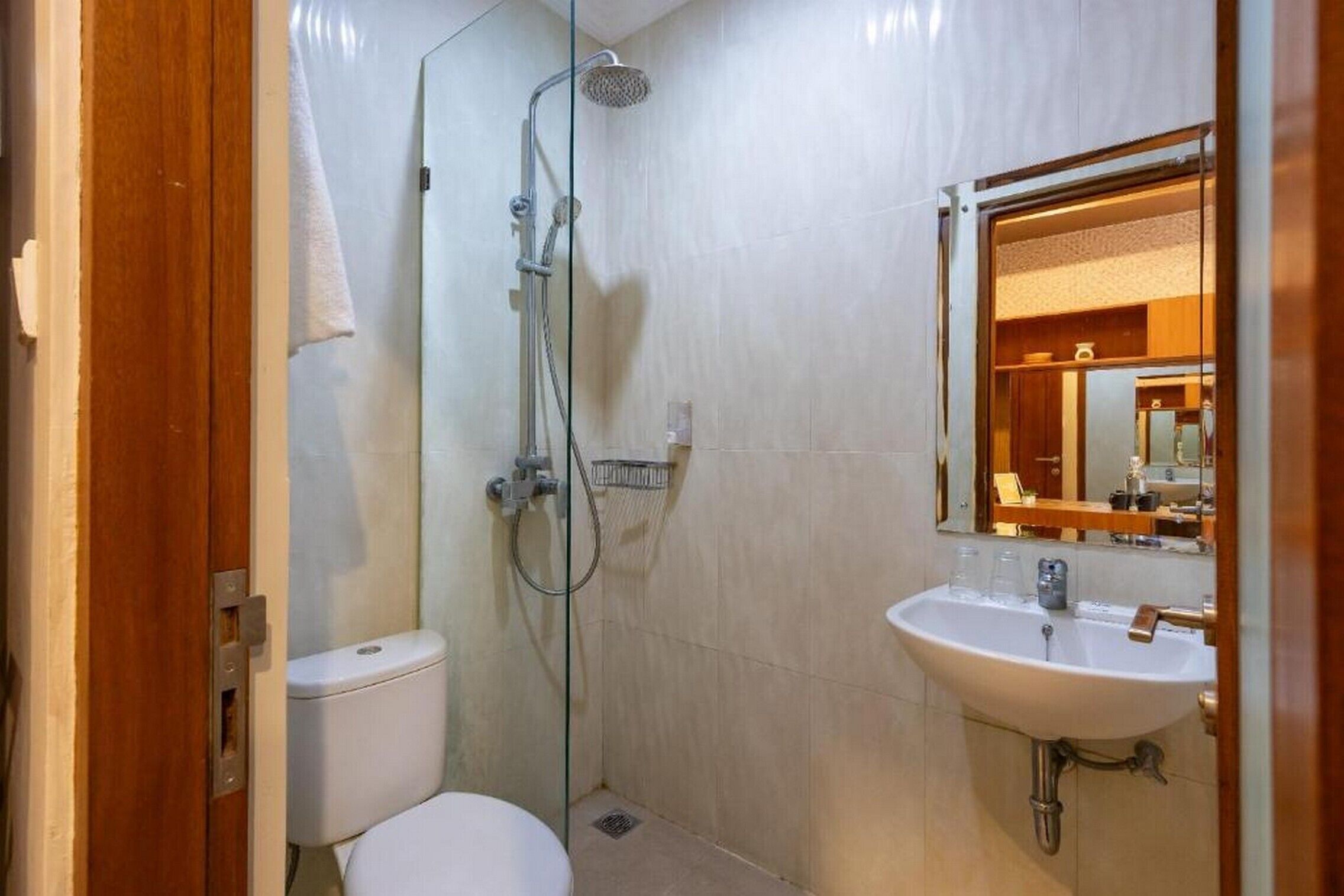 Une petite salle de bain avec des toilettes, une douche et un lavabo.